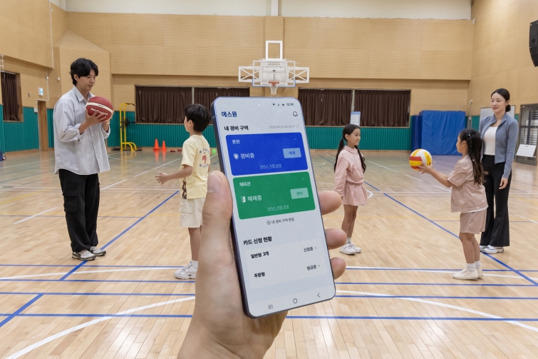 [보도자료 사진] 에스원 학교 안전 솔루션이 적용된 체육관 내부 상황을 모바일 앱으로 모니터링하고 있다.jpg